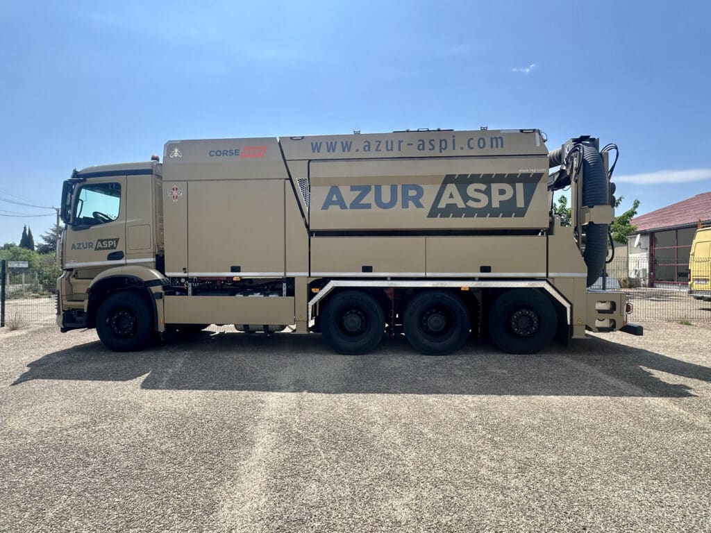 Camion aspirateur Azur Aspi : excavatrice par aspiration Camion aspirateur Azur Aspi beige, excavatrice par aspiration avec logo Corse Aspi et site web sur fond de ciel bleu.
