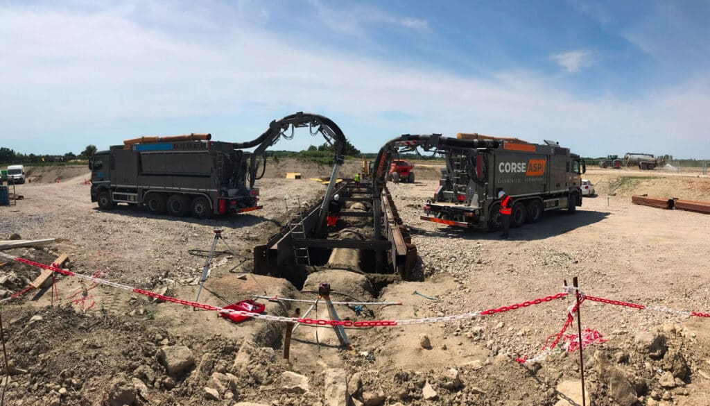 CORSE ASPI : Deux excavatrices aspiratrices en action sur TP. Deux excavatrices aspiratrices CORSE ASPI sur un grand chantier TP. Leurs bras articulés extraient les déblais d'une structure de forage ou de canalisation.